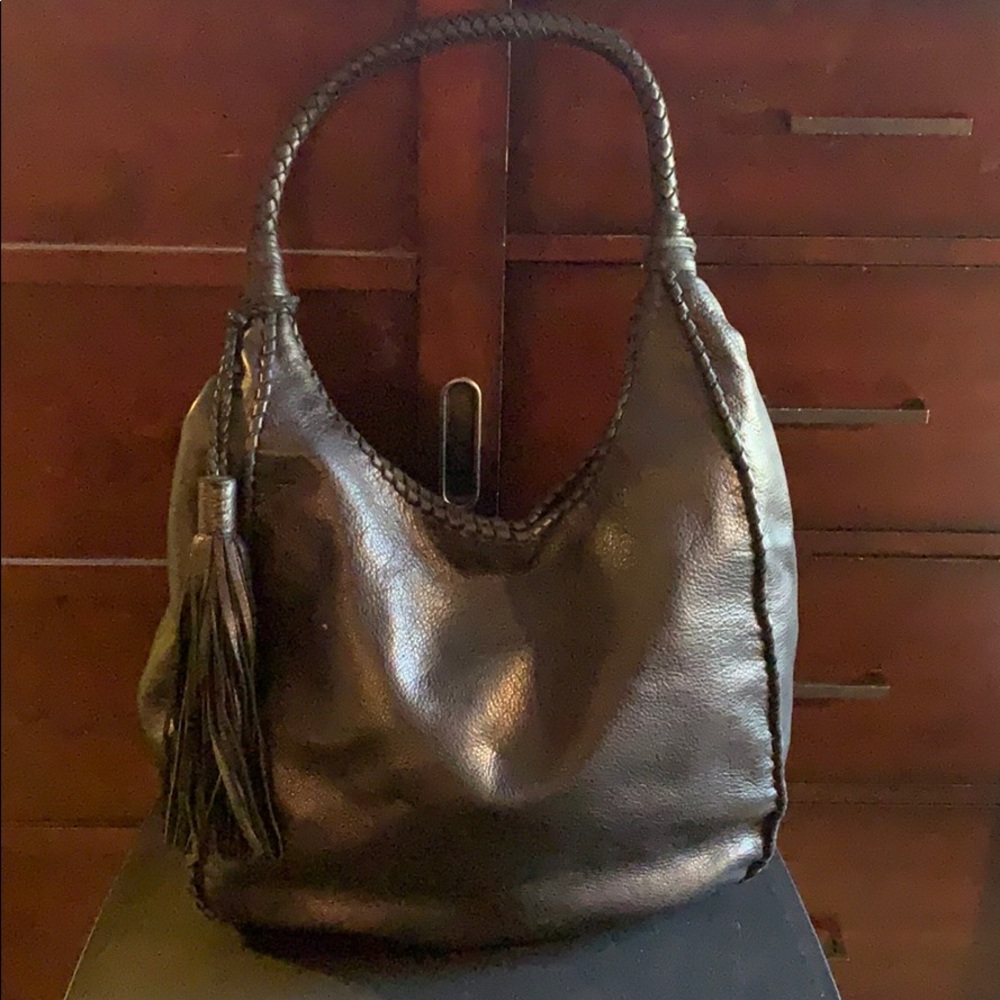 Large, black leather shoulder bag with tassel.